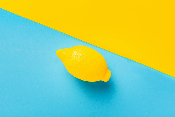 Fruit citron frais sur fond bleu pastel et jaune. Concept d'été minimal. Pose plate. Vitamine C
. - Photo, image