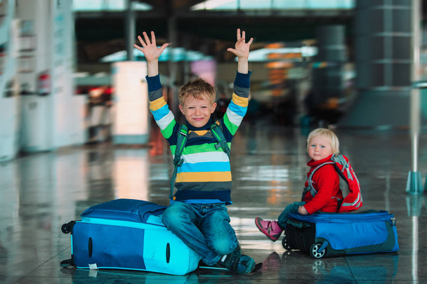 happy little boy and girl travel wait in airport - Foto, Imagen