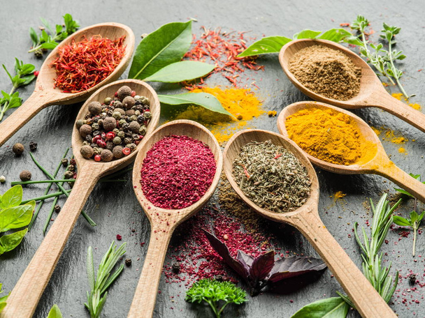 Assortment of colorful spices in the wooden spoons. - Foto, afbeelding