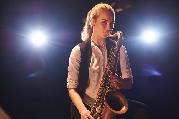 beautiful woman playing saxophone on stage  - Foto, imagen