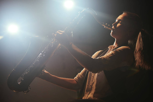 beautiful woman playing saxophone on stage  - Φωτογραφία, εικόνα