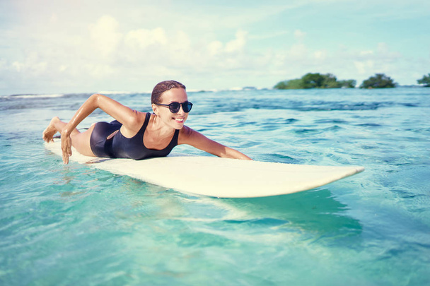 Happy Carefree Sexy Woman Surfing, Lying On Paddle, Surf Board In Sea Clear Water - Фото, изображение