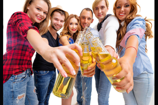Group of six happy smiling friends with bottles of beer having fun together - Foto, imagen