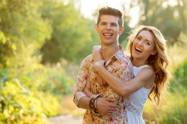 Retrato al aire libre de pareja riéndose abrazándose en el parque
. - Foto, Imagen