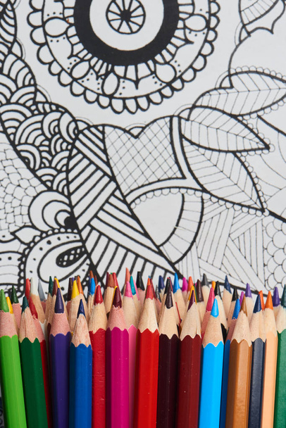 pile of bright rainbow crayons on coloring page, close-up - Foto, Bild