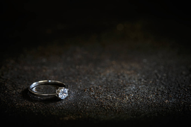 Ring with a polished gemstone on black background, space for your text - Foto, afbeelding