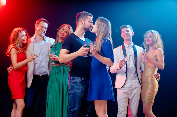 Group of seven happy smiling friends having fun together in night club. - Фото, зображення