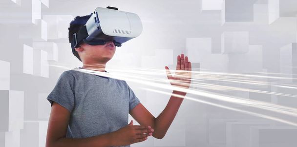 Boy playing using virtual reality headset against white background - Foto, Imagen