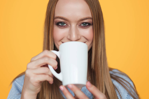 Content of woman drinking coffee on orange - Фото, зображення