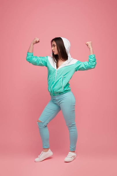 Strong woman in blue outfit on pink - Photo, image