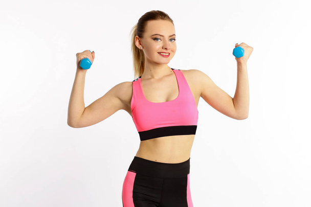 Young girl athlete, fitness with dumbbells isolated on white background - 写真・画像
