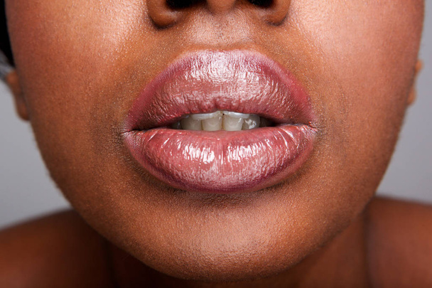 Εσωτερικη μερική πορτρέτο του όμορφη αφρικανική αμερικανική γυναίκα με γυαλιστερά lip gloss - Φωτογραφία, εικόνα