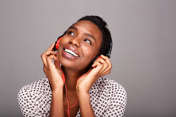 Close up portrait of happy black woman listening to music on headphones - Photo, Image