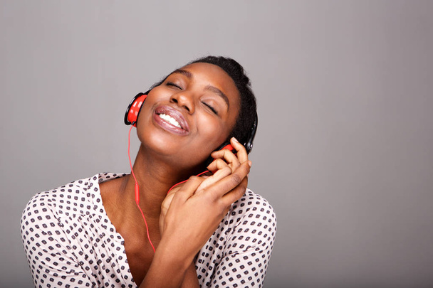 Close up portrait of happy woman listening to music on headphones with eyes closed - Photo, Image