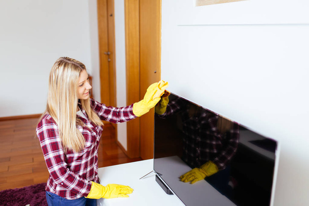 Bella giovane donna sorridente pulizia casa con panno in microfibra
. - Foto, immagini