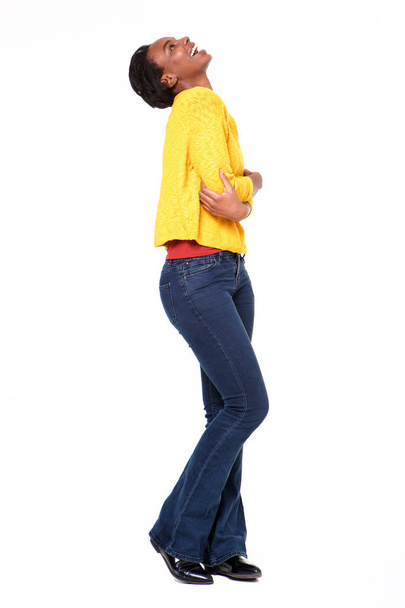Full body profile portrait of fashionable black woman laughing on white background - Foto, imagen