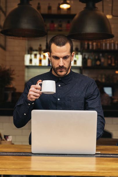 Businessman using his laptop in the Coffee Shop. Business Concept. - Fotó, kép