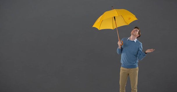 Cyfrowy kompozytowy mężczyzna parasol gospodarstwa z szarym tle - Zdjęcie, obraz