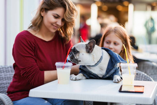 Madre e figlia godendo con il loro bulldog francese in mensa
 - Foto, immagini