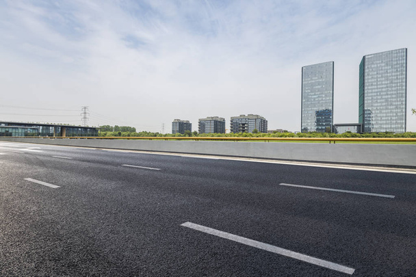 skyline panorámico y modernos edificios de oficinas de negocios con camino vacío, piso cuadrado de hormigón vacío - Foto, Imagen