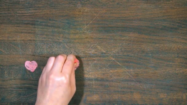 Closeup of hand draws on a wooden board. Figures of hearts. - Záběry, video