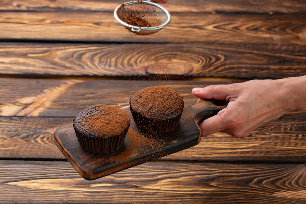 csokoládé cupcakes egy fából készült hajón meghintjük csokoládé. - Fotó, kép