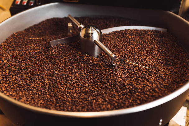 Roasted aromatic coffee beans in a modern coffee roasting machine. - Photo, Image