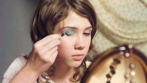 Little girl clumsily using sisters eyeshadows, wants to look like adult, closeup - Foto, immagini