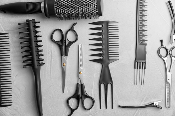 Flat lay composition with professional hairdresser tools on grey background - Foto, Imagem