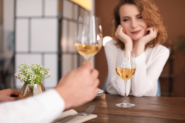 Young couple with glasses of delicious wine in restaurant - Fotoğraf, Görsel