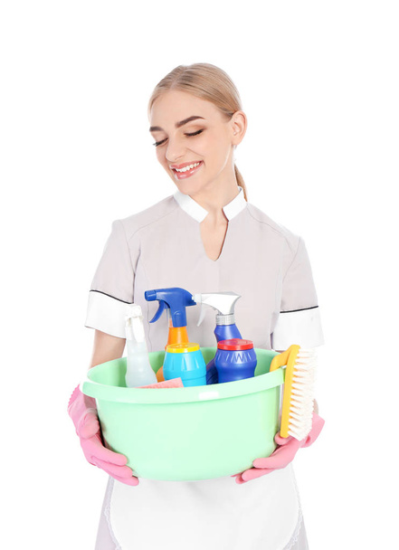 Camarera joven sosteniendo lavabo de plástico con detergentes sobre fondo blanco
 - Foto, Imagen