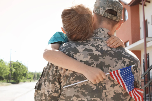 American soldier hugging with his son outdoors. Military service - Photo, image