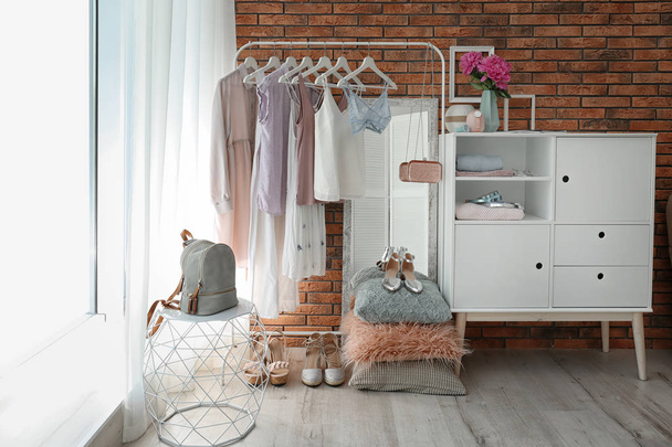 Stylish dressing room interior with clothes on rack - Photo, image