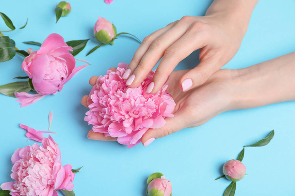 Woman holding beautiful peony flower on color background - 写真・画像