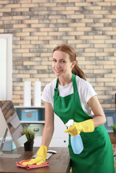 Mujer joven en delantal y guantes de oficina de limpieza
 - Foto, imagen