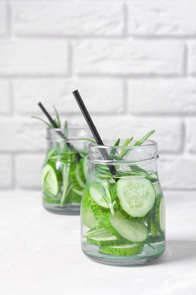Natural lemonade with cucumber and rosemary in jars on table - Foto, Imagem