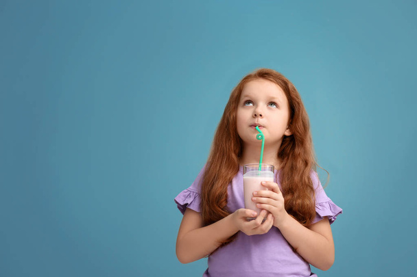 Маленька дівчинка зі склянкою смачного молока тремтить на кольоровому фоні
 - Фото, зображення
