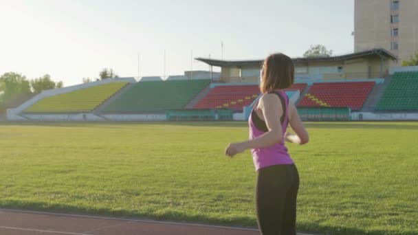 Beautiful fitness girl warming up before the start. Young athlete in training - Footage, Video