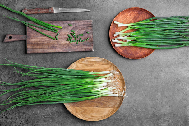 Beautiful composition with fresh green onion on table, top view - Foto, Bild