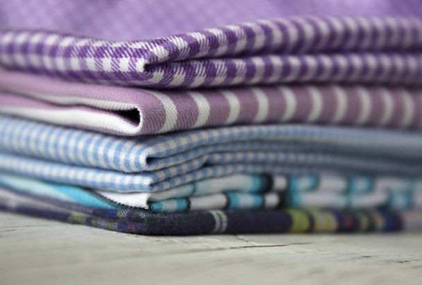 De nombreux types de tissus de coton en rayures et en cage sur un fond lilas. Tissus pourpre, bleu et turquoise pour la couture
 - Photo, image