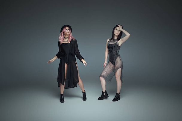 Dva módní dívky nosí černé trendy oblečení, které představují - Fotografie, Obrázek
