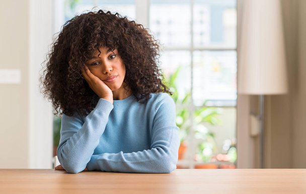Mujer afroamericana en casa pensando cansada y aburrida de problemas de depresión con los brazos cruzados
. - Foto, imagen