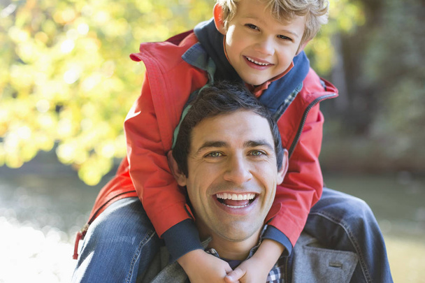 Vater trägt Sohn auf Schultern im Park - Foto, Bild