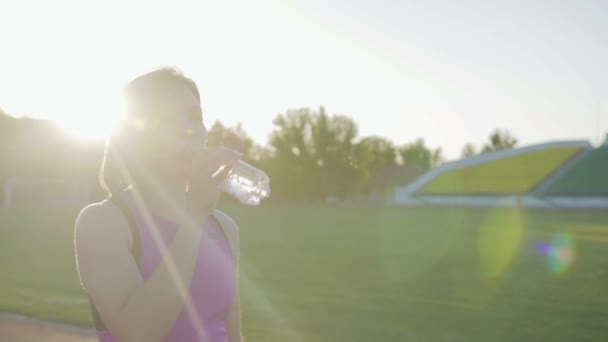 Nádherné fitness holka pitnou vodu z láhve během cvičení - Záběry, video