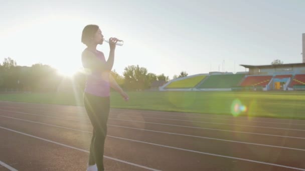 Nádherné fitness holka pitnou vodu z láhve během cvičení - Záběry, video