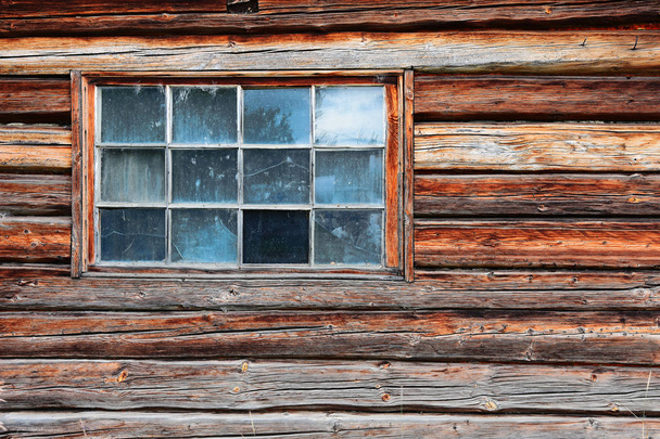 An image of an old dirty and broken window on a log cabin.  - Zdjęcie, obraz