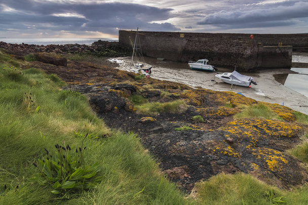 Amanecer en el puerto de Dunbar cuando baja la marea y las barcas queda estaticas, Escocia
 - Foto, imagen