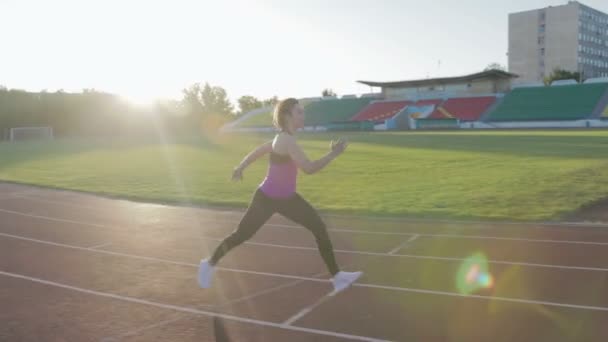 Gyönyörű fitness lány vonatok a stadionban. Egy fiatal sportoló fut a gátfutás - Felvétel, videó