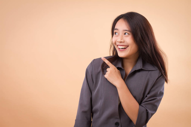 деловая женщина, указывающая вверх; портрет счастливой улыбающейся азиатской деловой женщины, указывающей вверх; деловые люди, указывающие, показывающие, представляющие концепцию; азиатская модель молодой женщины
 - Фото, изображение