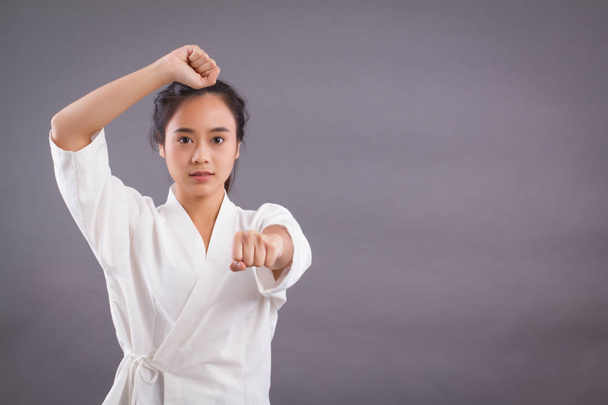 nő harcos portré; ázsiai nő gyakorló martial arts, vegyes harcművészetek, Mma, kick-ökölvívás, karate studio elszigetelt portré; lány harcos a képzés koncepciója; 20-as modell fiatal felnőtt ázsiai nő - Fotó, kép